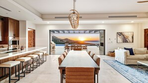 Una cocina moderna con armarios de madera, extractor de acero inoxidable y una zona de bar con taburetes.