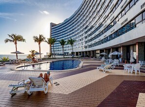 Ett poolområde vid hotellet med solstolar, parasoller och en swimmingpool.