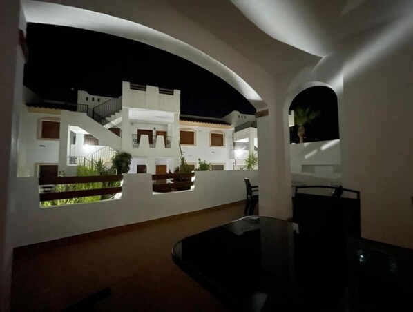 A modern building with a courtyard, white walls, and balconies.