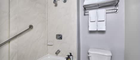 A bathroom with a bathtub, a toilet, and a towel rack.