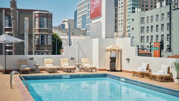 Una piscina al aire libre, sillones reclinables de piscina