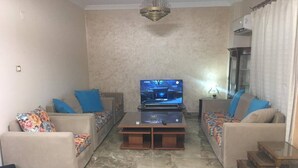 Una sala de estar con dos sofás, una mesa de centro y un televisor.