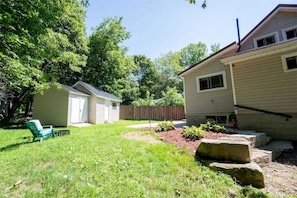 Enjoy a serene outdoor space with a well-manicured lawn and a charming garden.