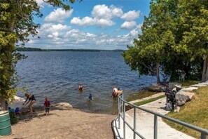 Guests can enjoy water activities and scenic views of the lake from the grassy area with a concrete path leading to the water.