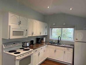 Enjoy cooking in this well-equipped kitchen with microwave, stove, and sink.