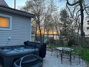 Relax in a hot tub surrounded by serene natural views and a tranquil outdoor space.