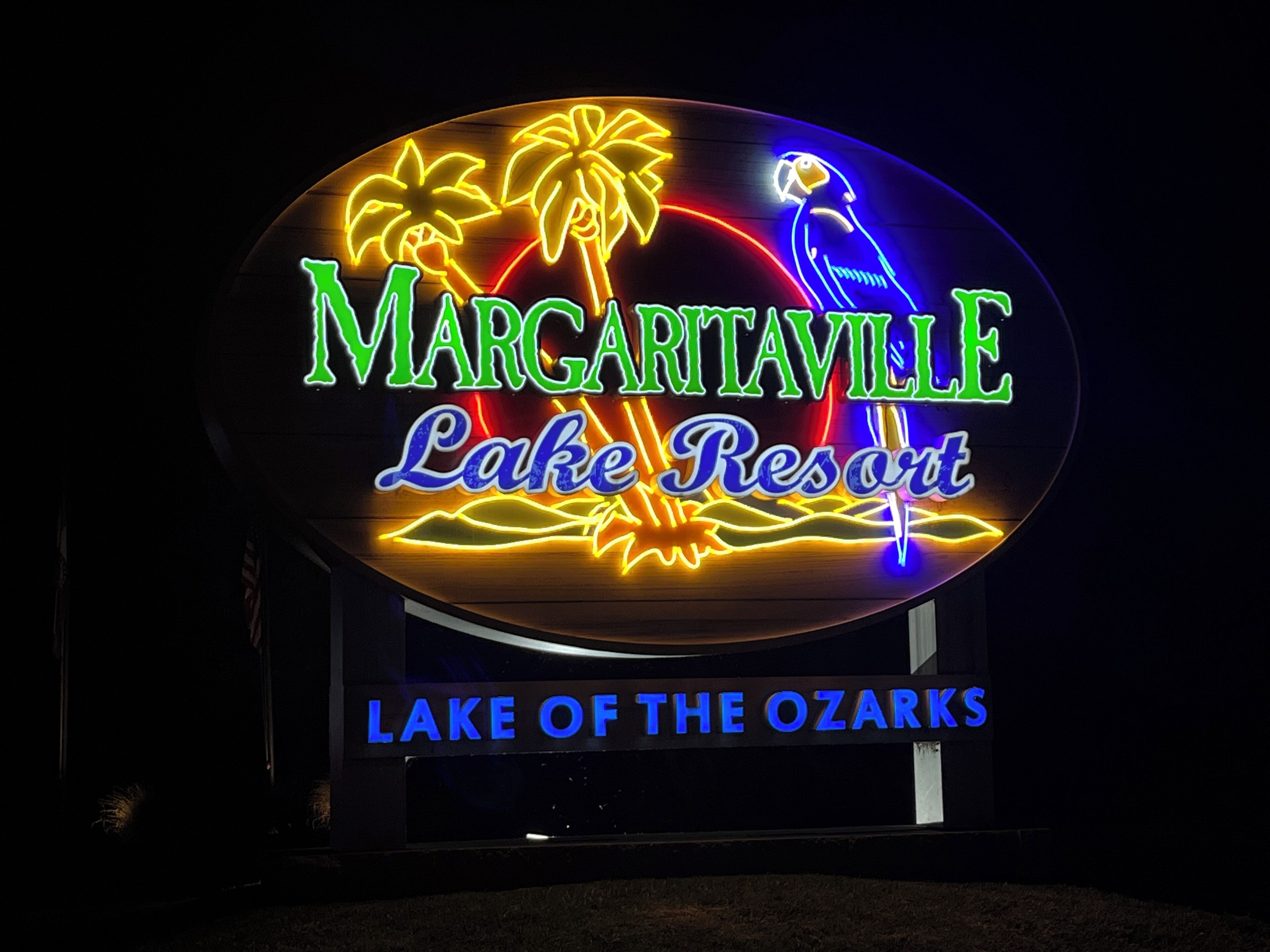 Une enseigne au néon pour le Margaritaville Lake Resort, avec des palmiers et un perroquet.