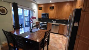 A kitchen with wooden cabinets, a microwave, stove, and refrigerator.