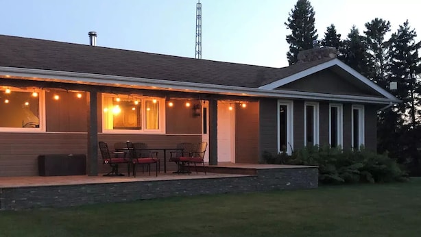 Un patio couvert avec des meubles d’extérieur et des guirlandes lumineuses.