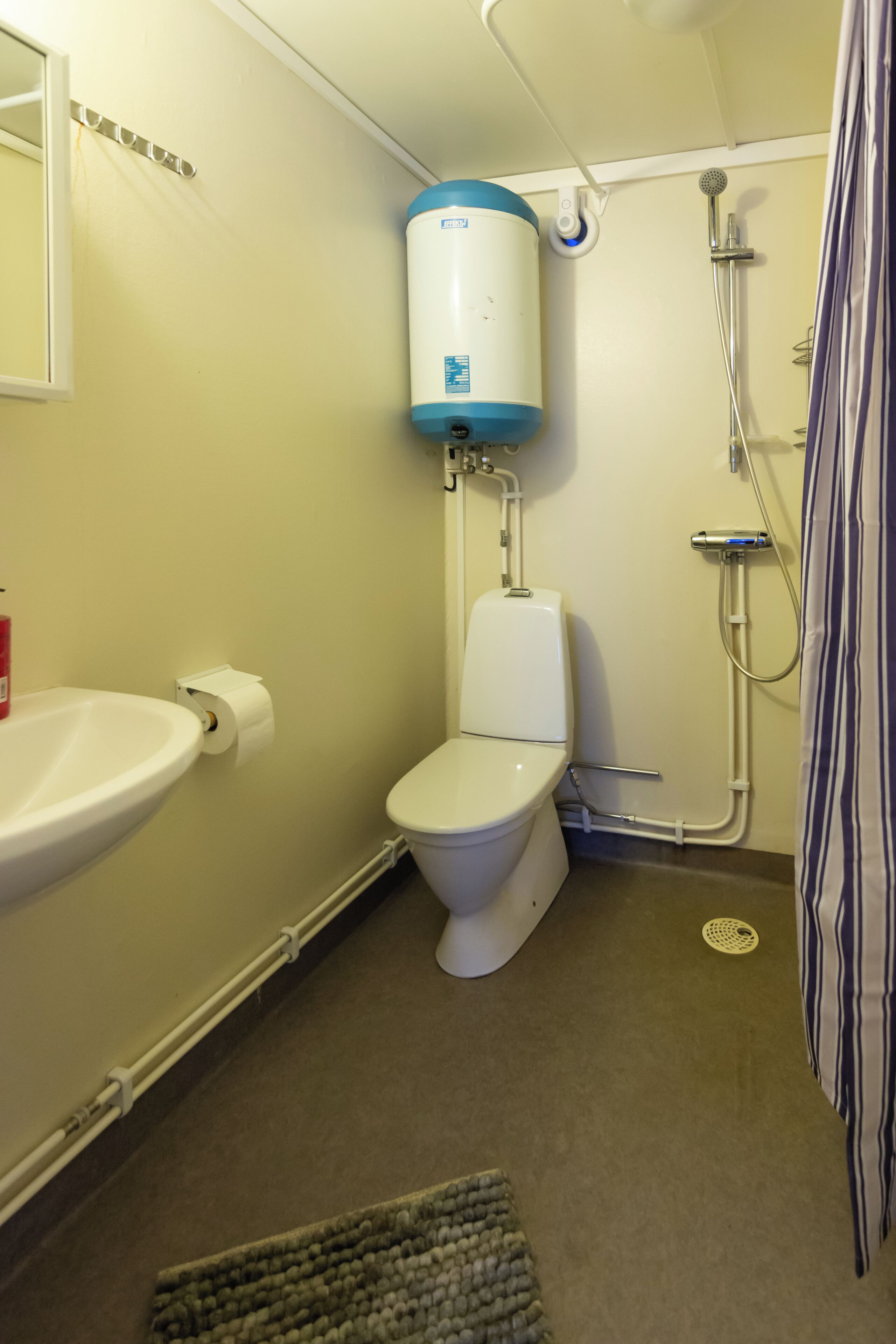 Un bagno piccolo con WC, lavandino e doccia.