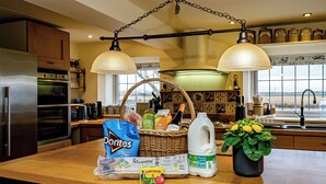 A kitchen with a refrigerator, double oven, and a large island with a basket of groceries, a milk jug, and a potted plant. - 2 bedroom accommodation in Reedham (Reedham)