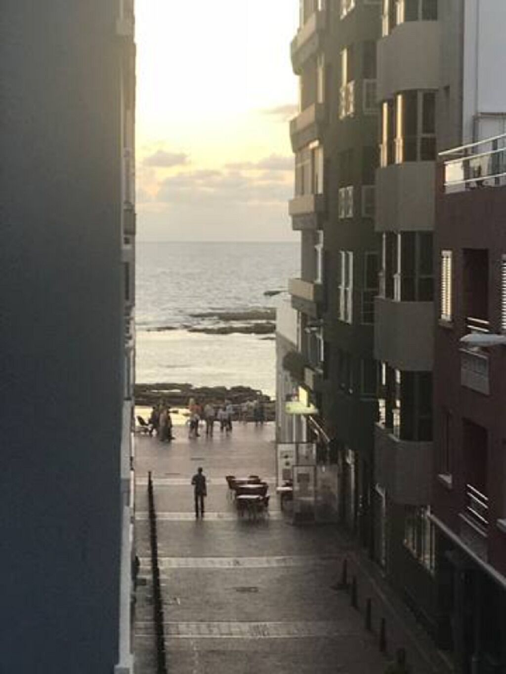 Een straat langs de kust, met gebouwen aan de ene kant en de zee aan de andere.