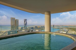A modern hotel pool with a panoramic city view, featuring high-rise buildings and a clear sky. - Conrad Bahrain Financial Harbour (Manama)
