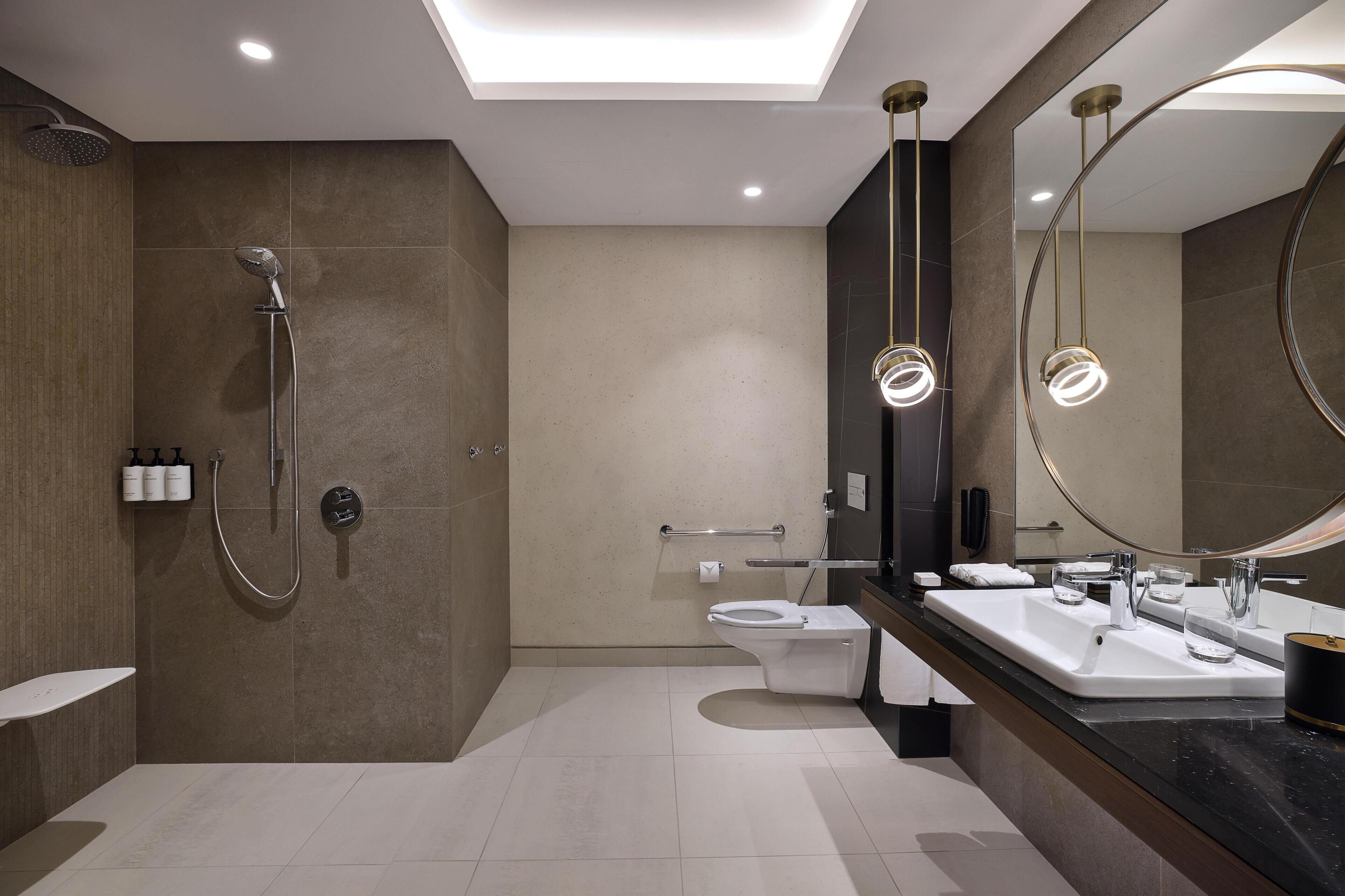 A modern bathroom with a shower, toilet, and dual sinks.