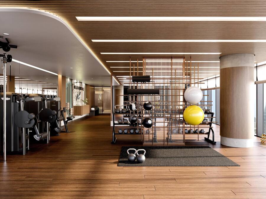 A modern gym with various exercise equipment, a kettlebell set, and a large window offering a city view.