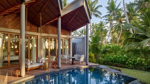 A modern resort with a swimming pool, covered seating area, and lush tropical surroundings. - Waldorf Astoria Seychelles Platte Island (Platte Island)