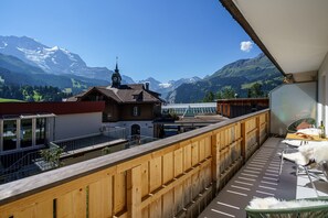 Enjoy breathtaking views of the surrounding mountains from this balcony with a church and clock tower in the distance.