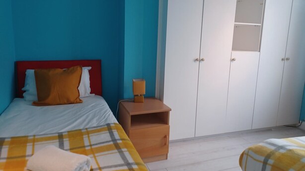 Une chambre à coucher comprenant un lit, une table de chevet, une armoire et une petite table.