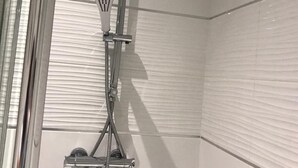 A modern shower with a handheld showerhead and a fixed overhead showerhead, both mounted on a chrome fixture. - HU1 Stylish cosy central apartment  H3 (Hull)