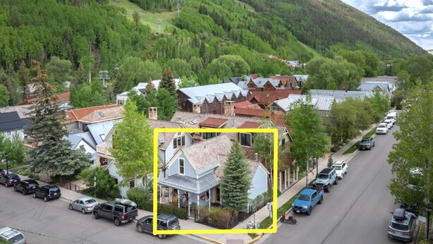 A residential area with houses, a street, and a mountainous backdrop.