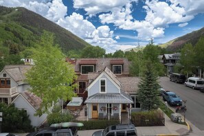 A residential area with houses, a hot tub, and a street with parked cars.