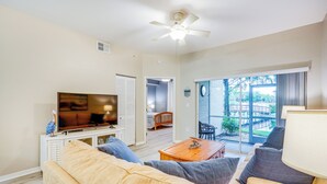 A living room with a TV, sofa, and a ceiling fan. - Fort Myers Condo: Community Pool + Fitness Center (Fort Myers)