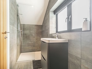 A modern bathroom with a shower, bathtub, and a sink. - The Old Coach Garage (Gerrans)