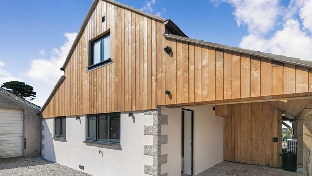 A modern building with a sloped roof, a garage, and a gravel driveway. - The Old Coach Garage (Gerrans)