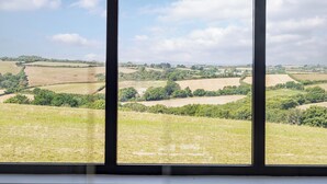 A view through a window of a rural landscape with fields and trees. - The Old Coach Garage (Gerrans)