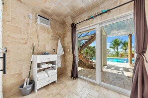 Une salle de bain équipée d’une douche, d’un lavabo, d’un porte-serviettes et d’un seau.