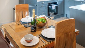 Una cucina moderna con mobili grigi, forno integrato e schienale blu.