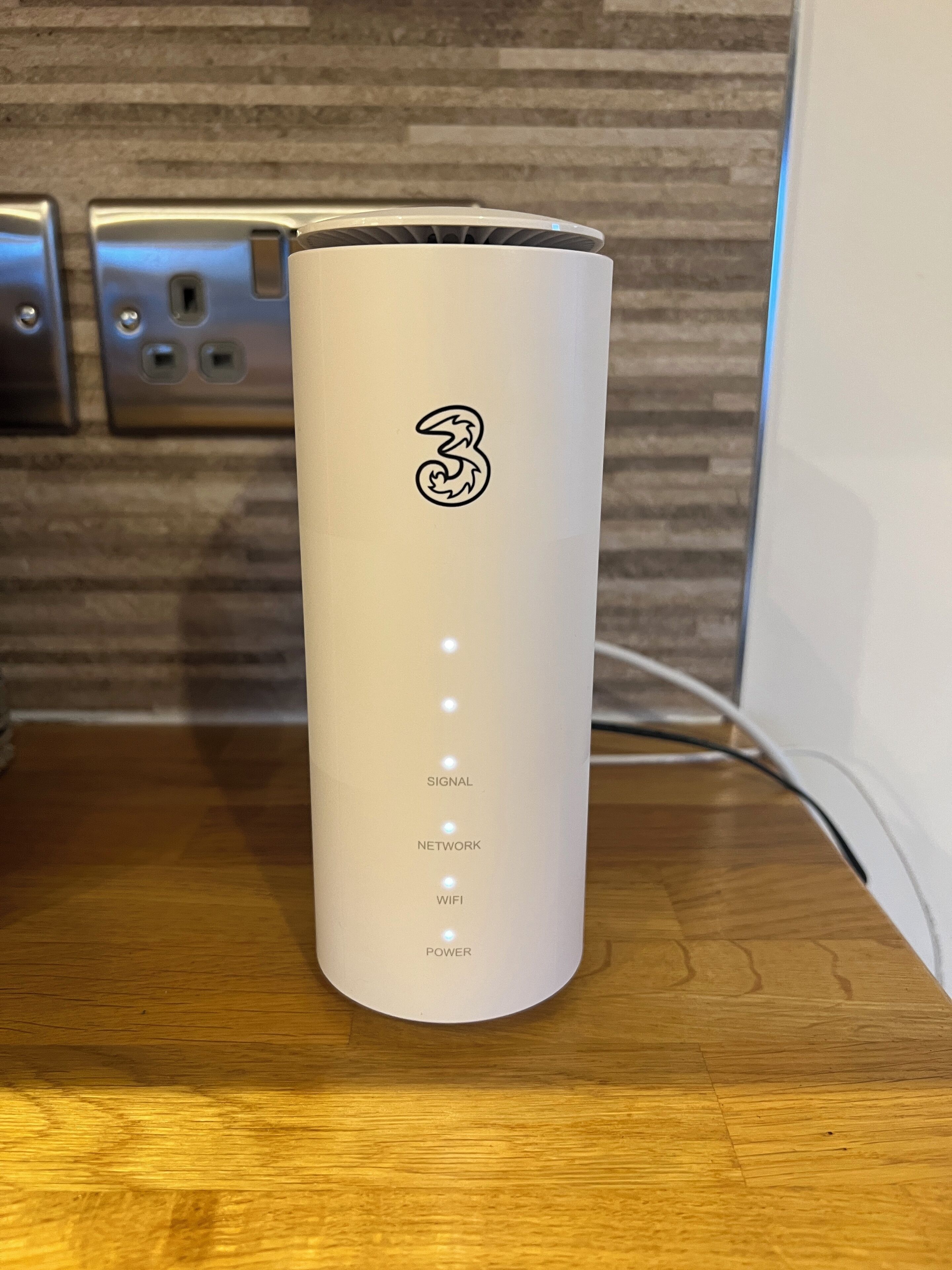A cylindrical device with a logo and four labeled indicators: SIGNAL, NETWORK, WIFI, and POWER.