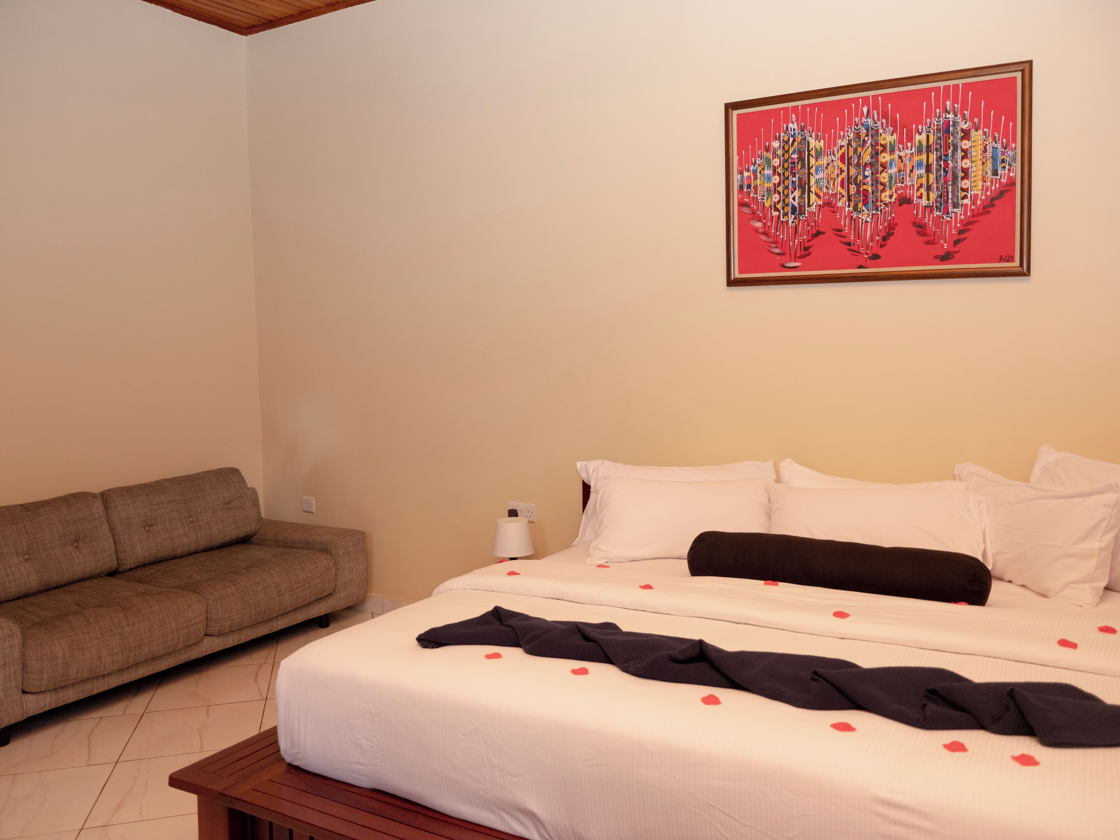 Una camera d'hotel con un letto, un divano e un quadro appeso al muro.