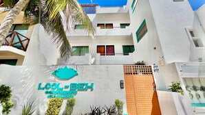 A modern building with a sign reading "LOOL-BEH condominiums." - Mid-Island Condo with Rooftop Balcony (Isla Mujeres)