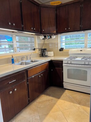 Enjoy cooking in this kitchen with a window offering a view of the outdoors, featuring a gas range, sink, and appliances.