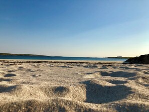 Une plage avec un ciel dégagé et une mer calme.