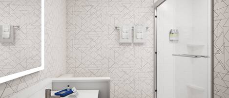 A modern bathroom with a geometric patterned wall, a white sink with a chrome faucet, and a glass shower enclosure.