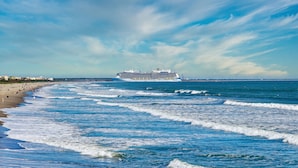 A cruise ship approaching a beach with waves and a clear sky. - Holiday Inn Express Cape Canaveral by IHG (Cape Canaveral)