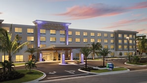 A hotel with a modern facade, multiple entry points, and a well-lit entrance. - Holiday Inn Express Cape Canaveral by IHG (Cape Canaveral)