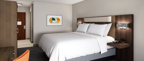 A modern hotel room with a large bed, a desk, and a nightstand.