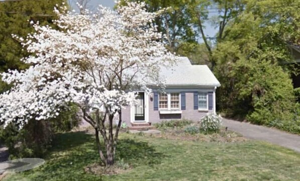 Welcome to a charming single-story home with a front porch and beautifully manicured lawn.