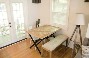 Cozy retreat with a large window, wooden table, and comfortable bench.