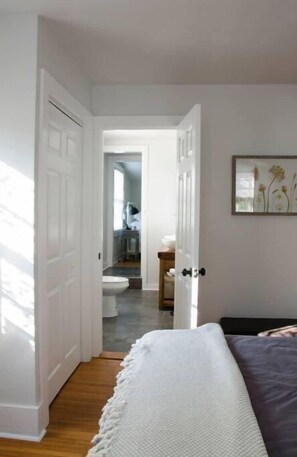 Relax in a spacious room with a large bed, framed artwork, and a clean, minimalist design.