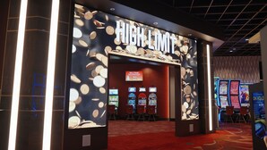 Entrada a un casino con un letrero que dice 'HIGH LIMIT' y máquinas tragamonedas en su interior.