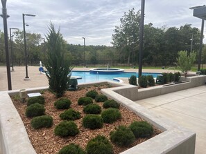 A landscaped area with a swimming pool, surrounded by trimmed hedges and trees. - Osage Casino Hotel Pawhuska (Pawhuska)