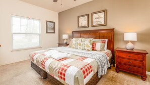 A bedroom with a large bed, two bedside tables, a ceiling fan, and a window with blinds. - Spacious 3BR Townhome in Kissimmee, perfect for family getaways! (Kissimmee)