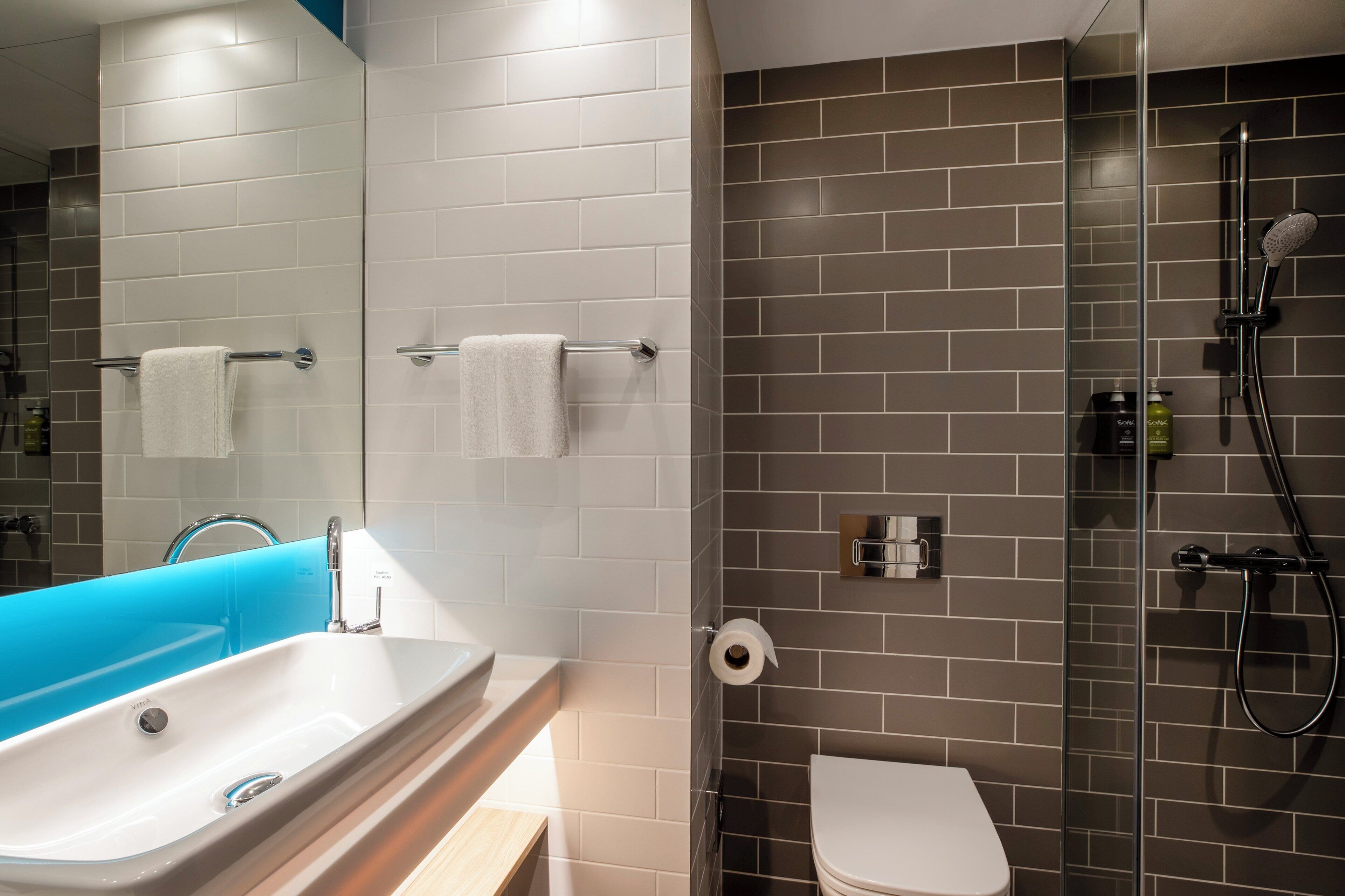 Een moderne badkamer met een bad, toilet en douche.