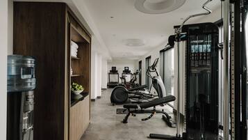 A modern gym with exercise equipment, a water dispenser, and a treadmill.