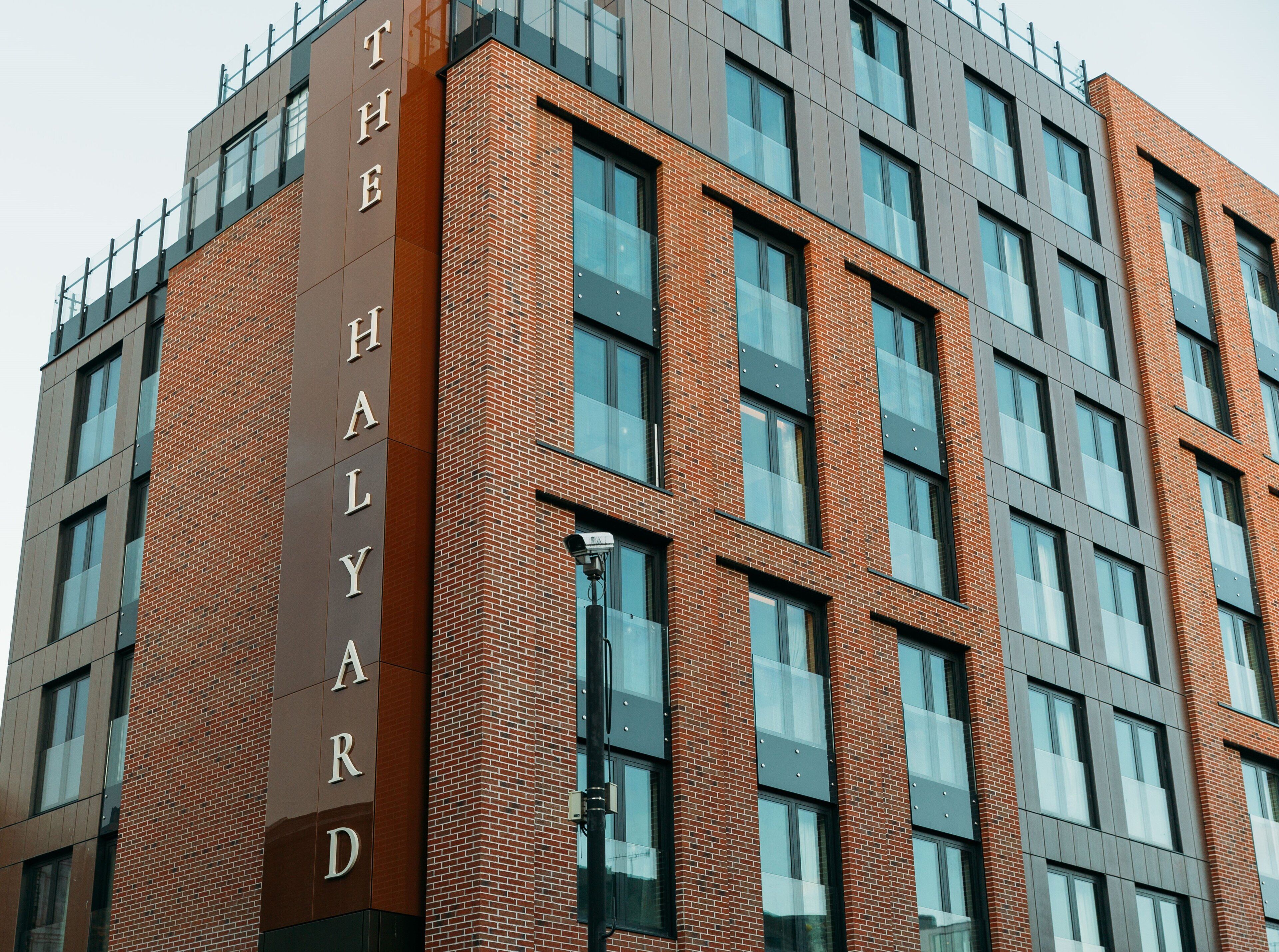 Un edificio de varios pisos con un letrero llamativo que dice 'THE HALLARD'.