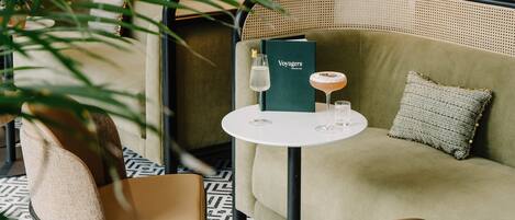 A cozy seating area with a round table, a menu, and a drink.